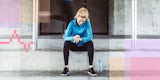 A runner pauses her workout to check her fitness tracker.