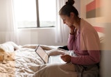 A sick patient talks to her doctor from the comfort of her bed.